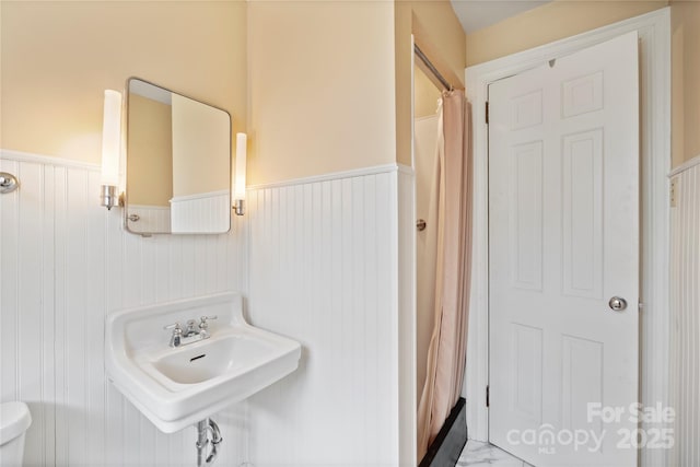 431 Sullivan Rd, Statesville, NC 28677 - bathroom with wainscoting, toilet, a sink, curtained shower, and marble finish floors