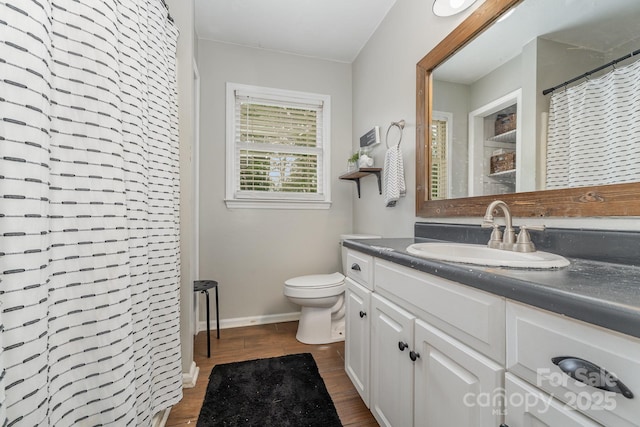 full bathroom with a shower with shower curtain, baseboards, toilet, wood finished floors, and vanity