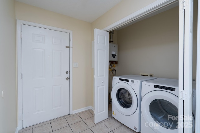 laundry room with washing machine and clothes dryer, light tile patterned floors, water heater, and baseboards