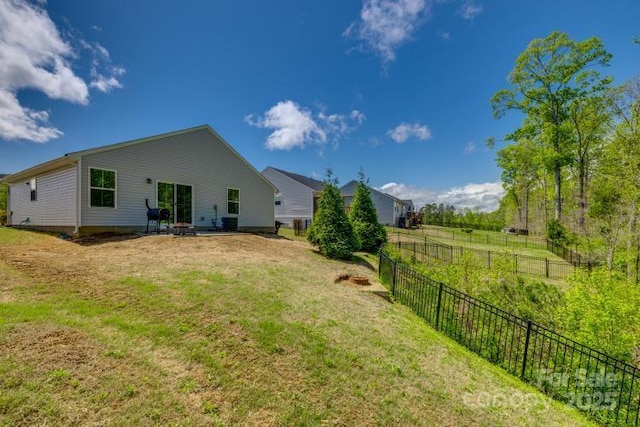 back of property featuring a yard and fence