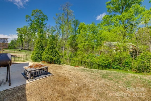 view of yard with fence and an outdoor fire pit