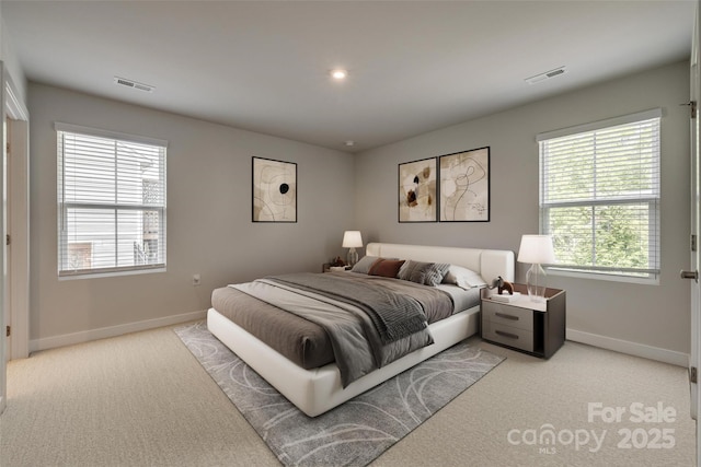 bedroom featuring visible vents, baseboards, and light colored carpet