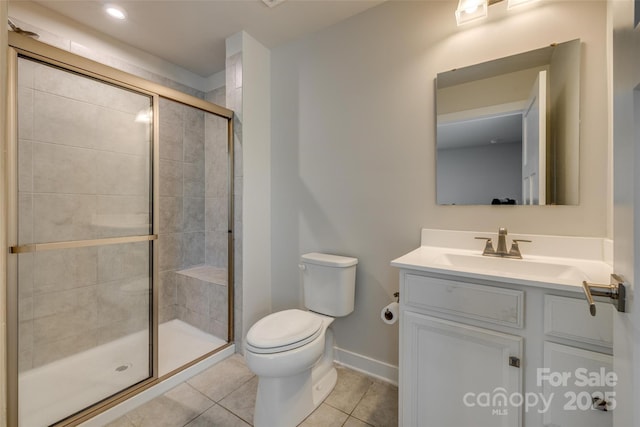 bathroom with tile patterned floors, toilet, baseboards, a shower stall, and vanity