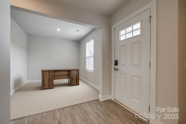 entryway with baseboards, wood finished floors, and visible vents