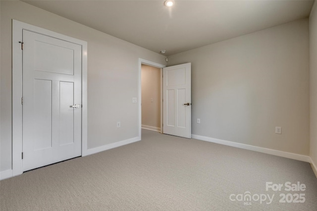 unfurnished bedroom featuring light colored carpet and baseboards