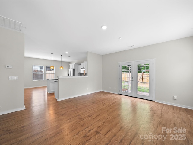 113 Devynn Ridge Ct, Mount Holly, NC 28120 - unfurnished living room featuring french doors, a wealth of natural light, wood finished floors, and visible vents