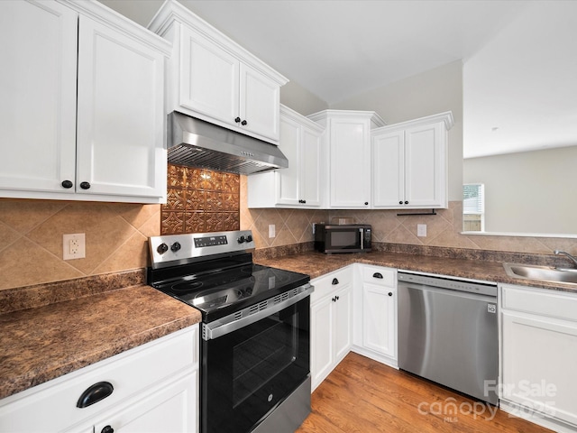 113 Devynn Ridge Ct, Mount Holly, NC 28120 - kitchen with under cabinet range hood, dark countertops, appliances with stainless steel finishes, and a sink