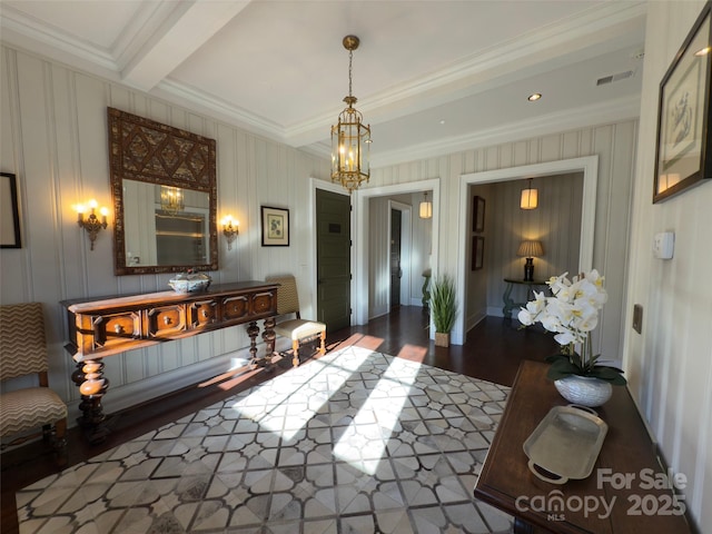 interior space with visible vents, a chandelier, ornamental molding, wood finished floors, and beam ceiling