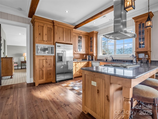 kitchen featuring island exhaust hood, beamed ceiling, a breakfast bar area, and stainless steel appliances