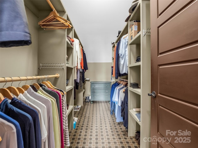 spacious closet with vaulted ceiling and tile patterned floors