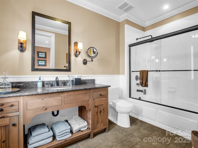 bathroom with toilet, vanity, crown molding, and visible vents