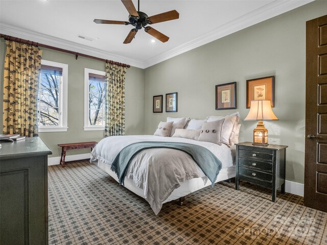bedroom featuring dark colored carpet, baseboards, visible vents, ceiling fan, and ornamental molding