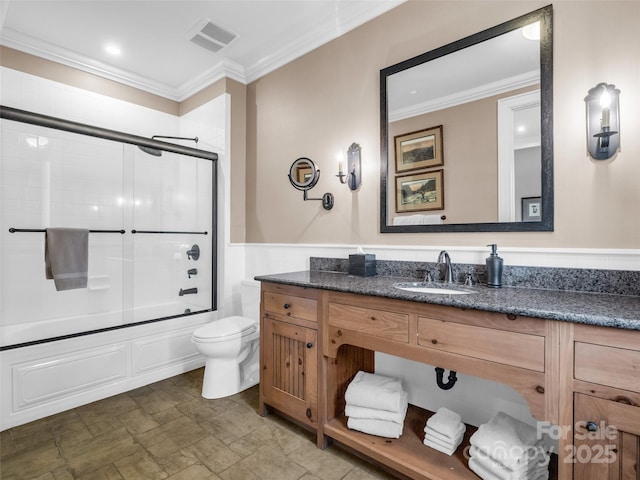 bathroom with toilet, vanity, crown molding, and visible vents