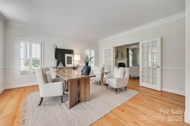 office space featuring plenty of natural light, a fireplace, ornamental molding, and wood finished floors