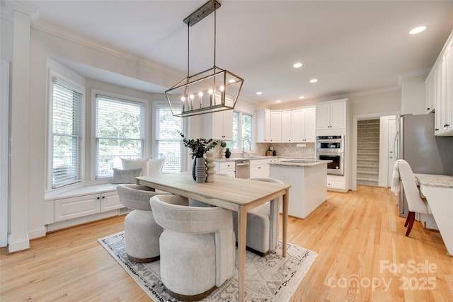 dining room with crown molding, recessed lighting, light wood-style flooring, and a chandelier