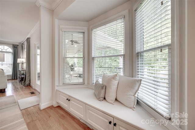 interior space with light wood-style floors, ornamental molding, and baseboards