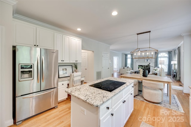 kitchen featuring crown molding, a center island, black electric cooktop, stainless steel fridge with ice dispenser, and open floor plan