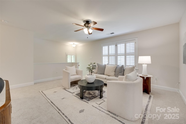 living area with baseboards, a ceiling fan, light colored carpet, and visible vents