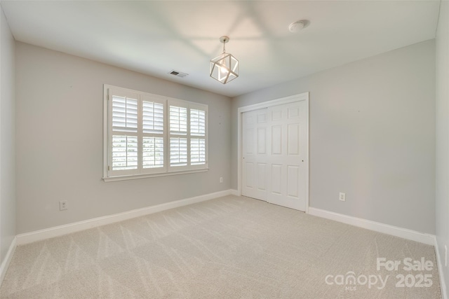 unfurnished bedroom featuring visible vents, baseboards, carpet floors, and a closet