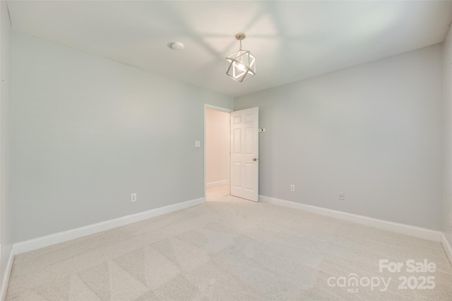 unfurnished room featuring baseboards and light colored carpet