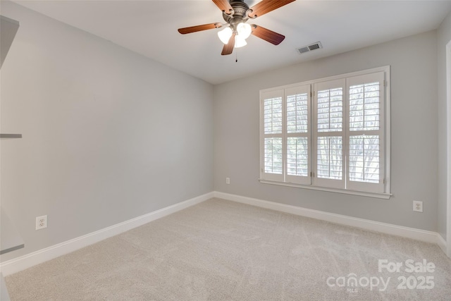 unfurnished room with baseboards, light colored carpet, ceiling fan, and visible vents
