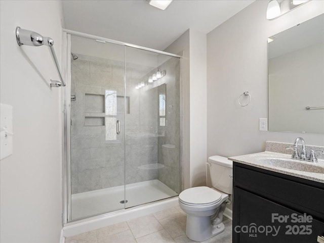 full bathroom featuring toilet, a stall shower, tile patterned floors, and vanity