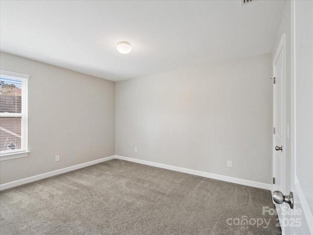 carpeted spare room with baseboards