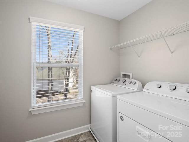 laundry area featuring washing machine and dryer, baseboards, and laundry area