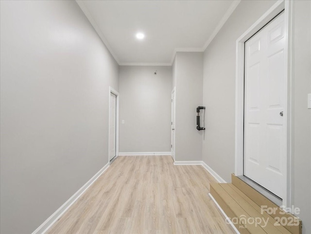 hallway with crown molding, baseboards, and light wood-type flooring