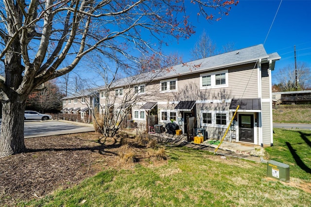 rear view of property featuring a lawn