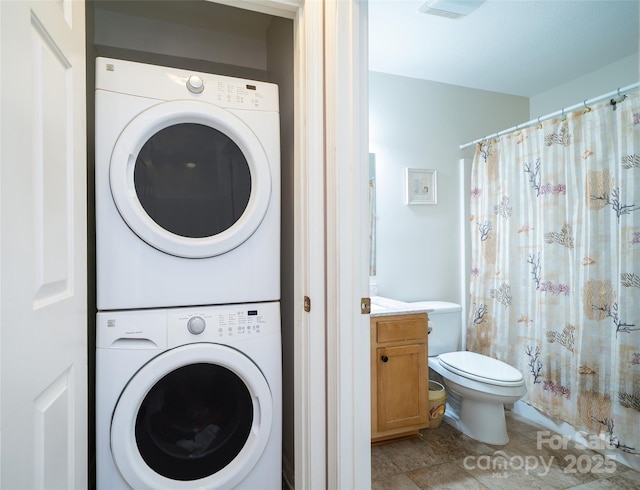 washroom featuring stacked washer and dryer, light tile patterned flooring, and laundry area