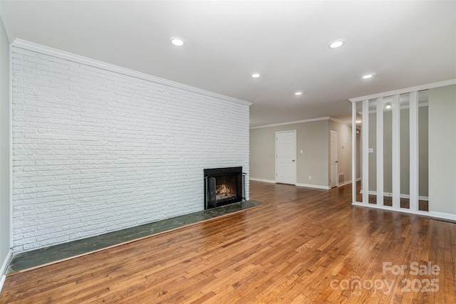 unfurnished living room with a fireplace, crown molding, wood finished floors, and recessed lighting