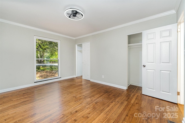 900 E Woodlawn Rd, Charlotte, NC 28209 - unfurnished bedroom with two closets, crown molding, and wood finished floors