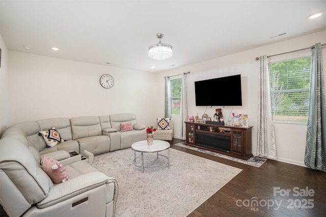 living area featuring visible vents, baseboards, recessed lighting, and dark wood finished floors