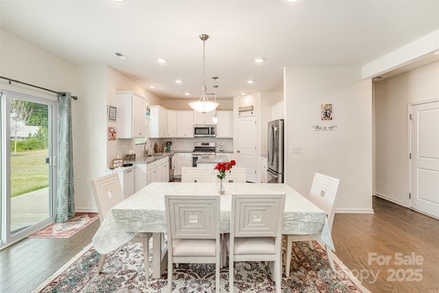 dining area with baseboards, wood finished floors, visible vents, and recessed lighting