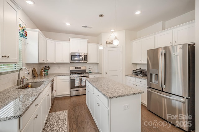 kitchen with dark wood-style floors, stainless steel appliances, visible vents, and a sink