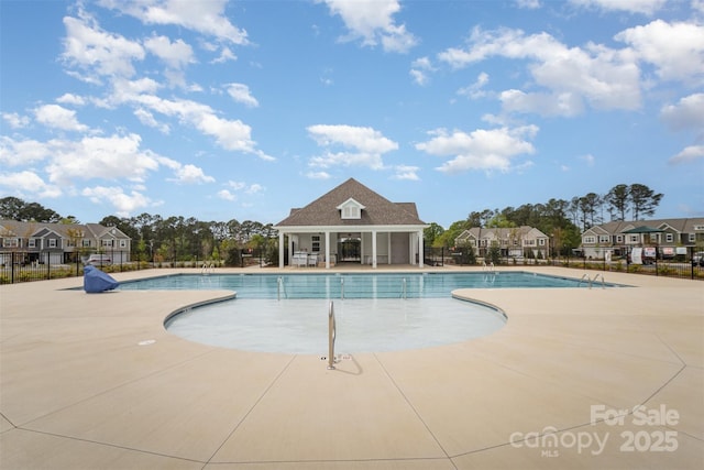 pool with a residential view, a patio area, and fence