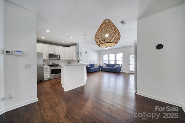 kitchen featuring a peninsula, visible vents, dark wood-style flooring, stainless steel appliances, and open floor plan