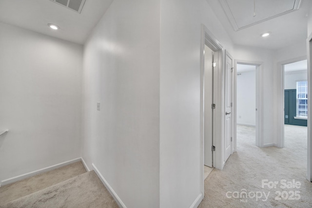 corridor featuring visible vents, baseboards, recessed lighting, attic access, and carpet flooring