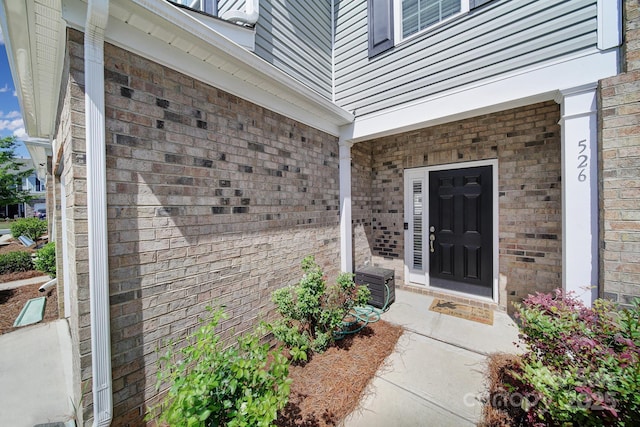 entrance to property featuring brick siding