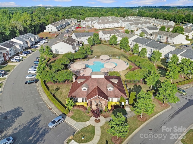 drone / aerial view with a wooded view and a residential view