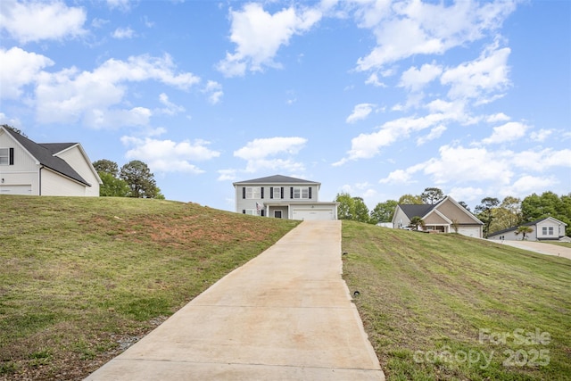 view of front of property featuring driveway, a garage, and a front yard