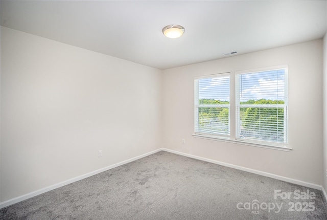 unfurnished room featuring baseboards, visible vents, and carpet floors