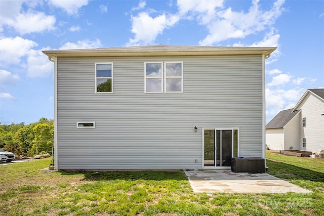 rear view of property with a patio and a lawn