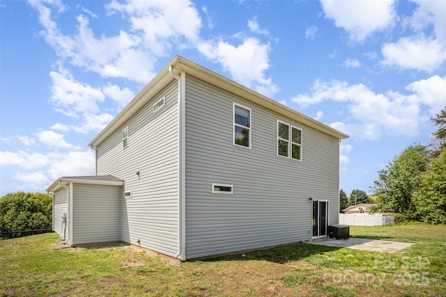 view of home's exterior featuring a patio, fence, and a lawn