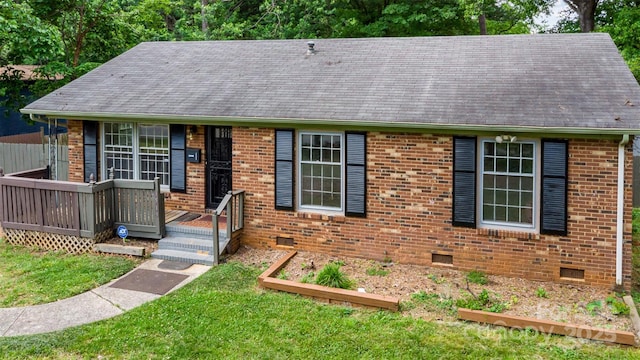 view of front of house with crawl space, brick siding, a front lawn, and a shingled roof
