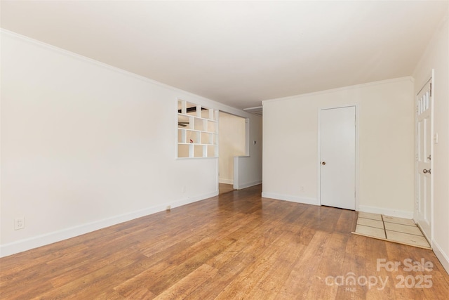 unfurnished bedroom featuring wood finished floors, baseboards, and ornamental molding