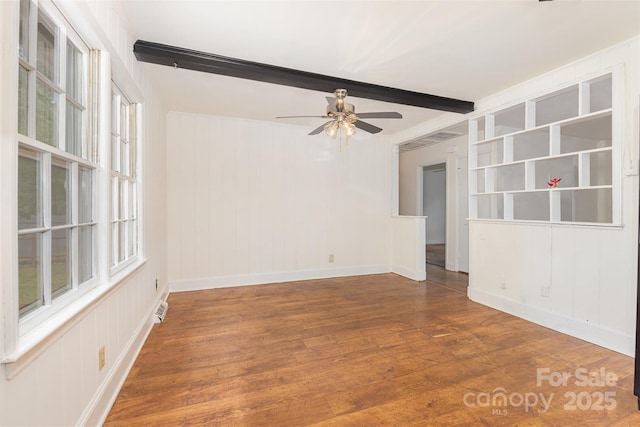 spare room featuring beamed ceiling, a ceiling fan, wood finished floors, and baseboards