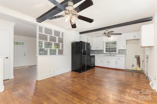 kitchen featuring black fridge with ice dispenser, a sink, a ceiling fan, light countertops, and beam ceiling