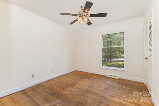 unfurnished bedroom with baseboards, wood finished floors, and a ceiling fan